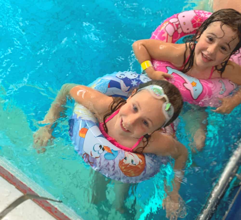 children in swimming pool on family holiday