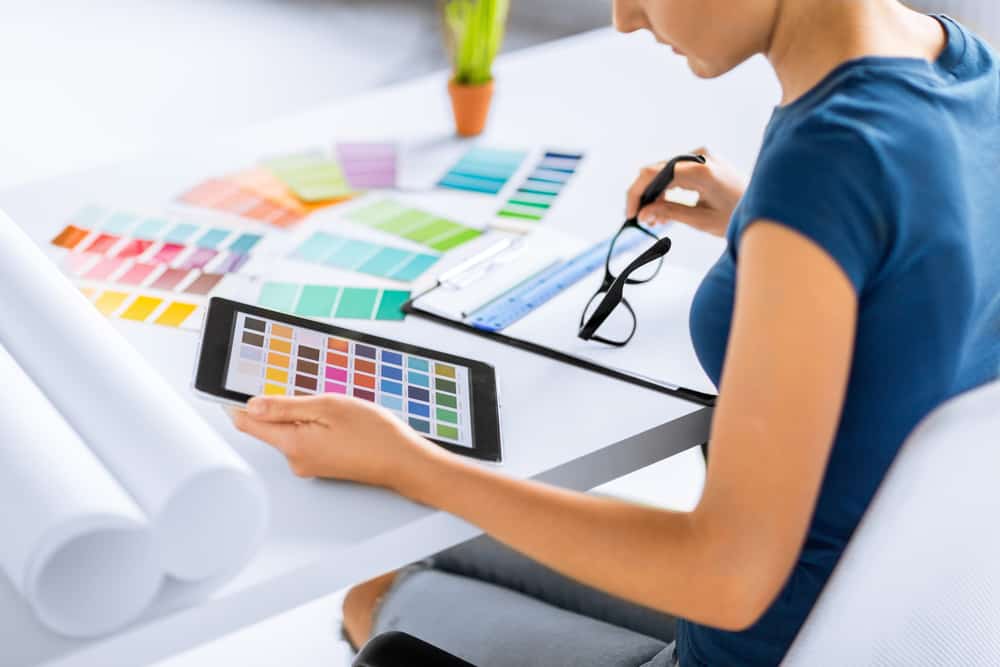 interior design, renovation and technology concept - woman working with color samples for selection