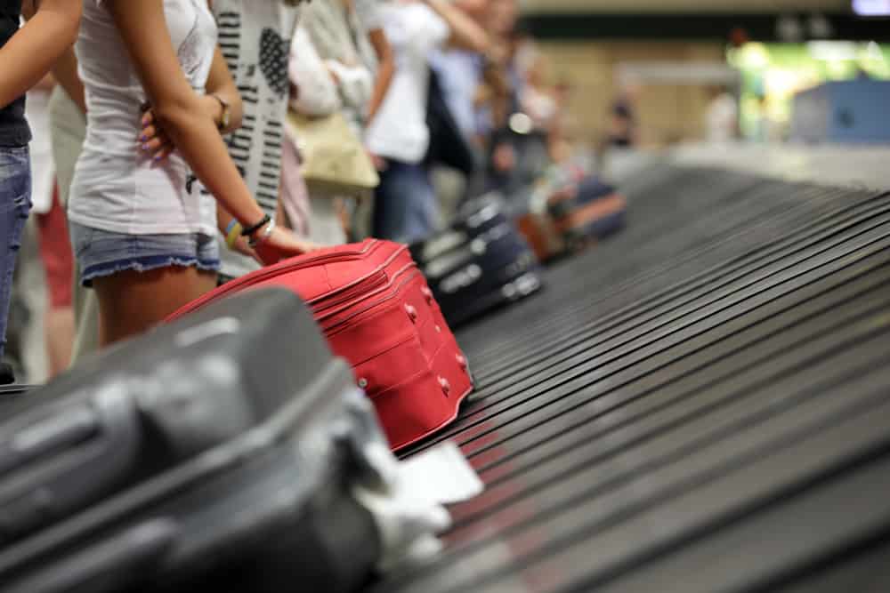 Suitcase on luggage conveyor belt in the baggage claim at airport