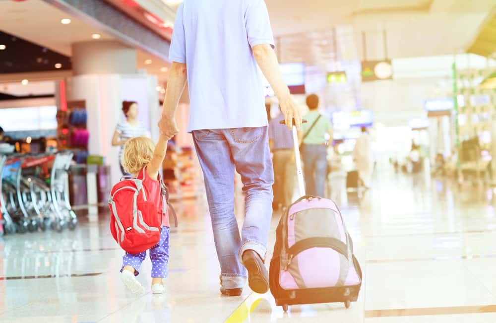 father and little daughter walking in the airport, family travel