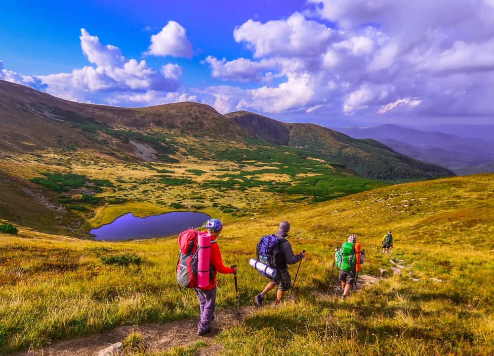  people are hiking in Carpathian mountains in summertime