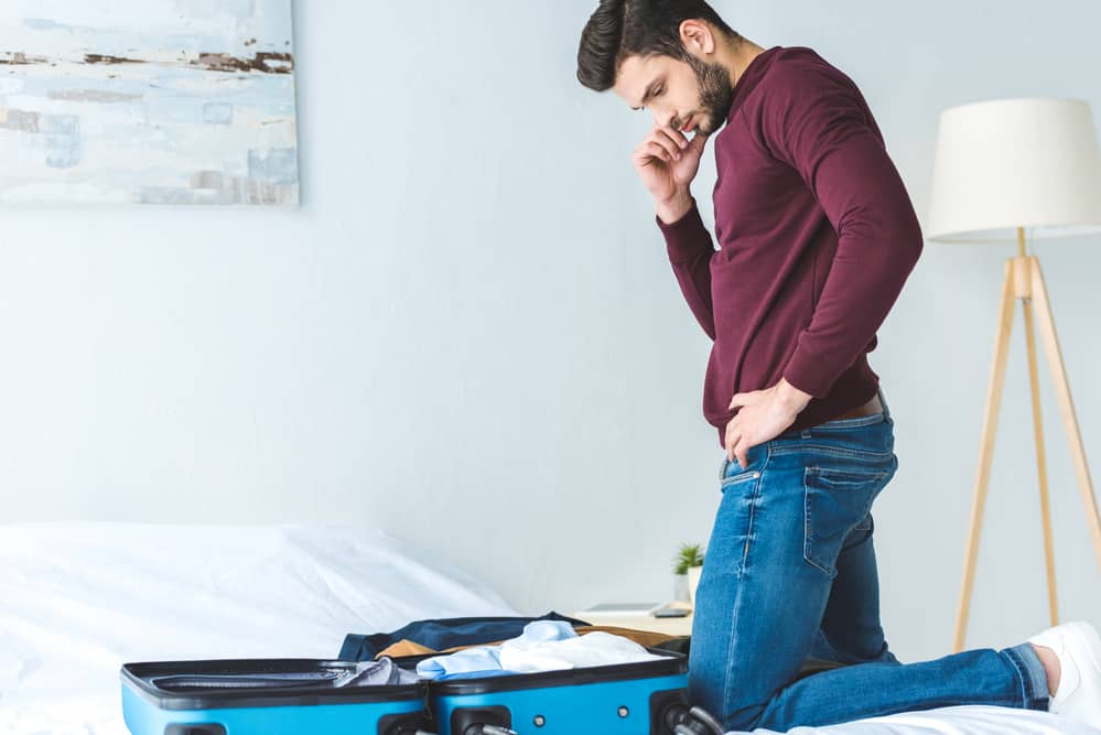 man looking at suitcase 