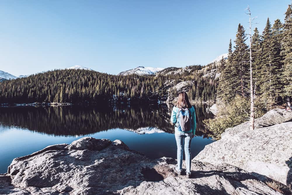 Woman tourist near Bear Lake at autumn in Rocky Mountain National Park. Colorado, USA.