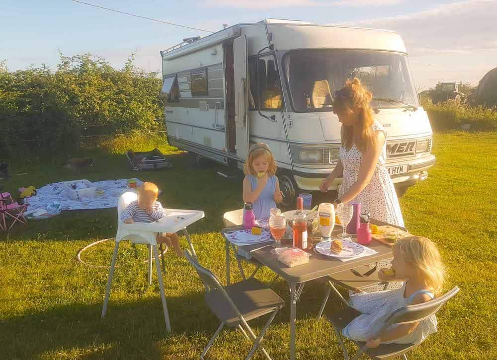 family having dinner outside van