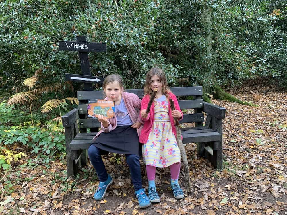 sitting on bench with witches sign