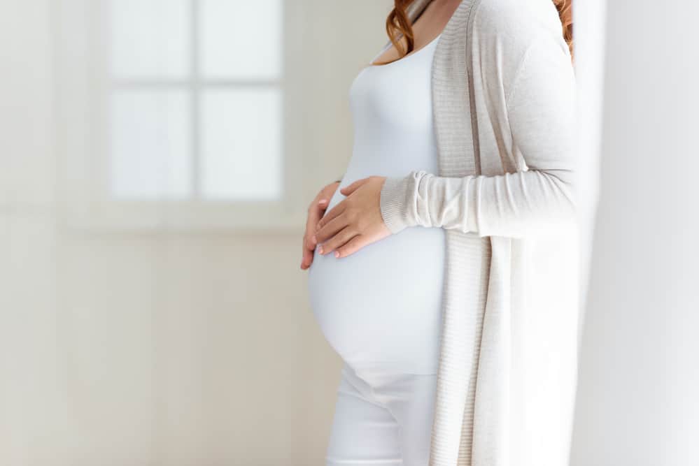 woman touching pregnant belly 