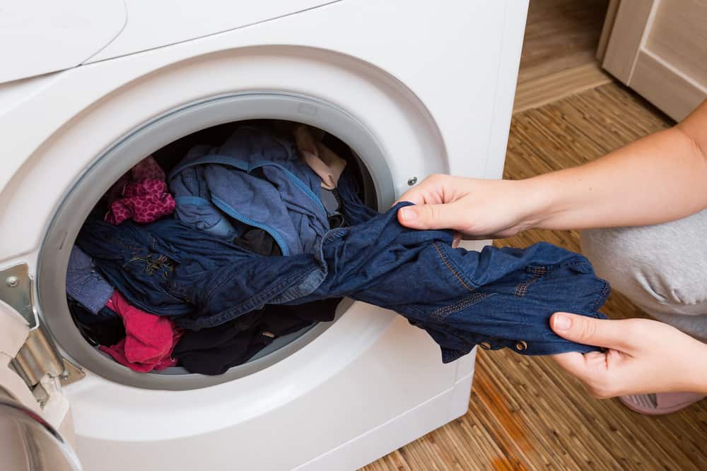 Woman pulls the Laundry out of the washing machine