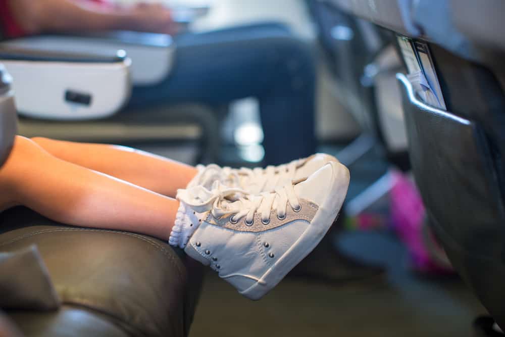 toddler feet on the seat in the plane