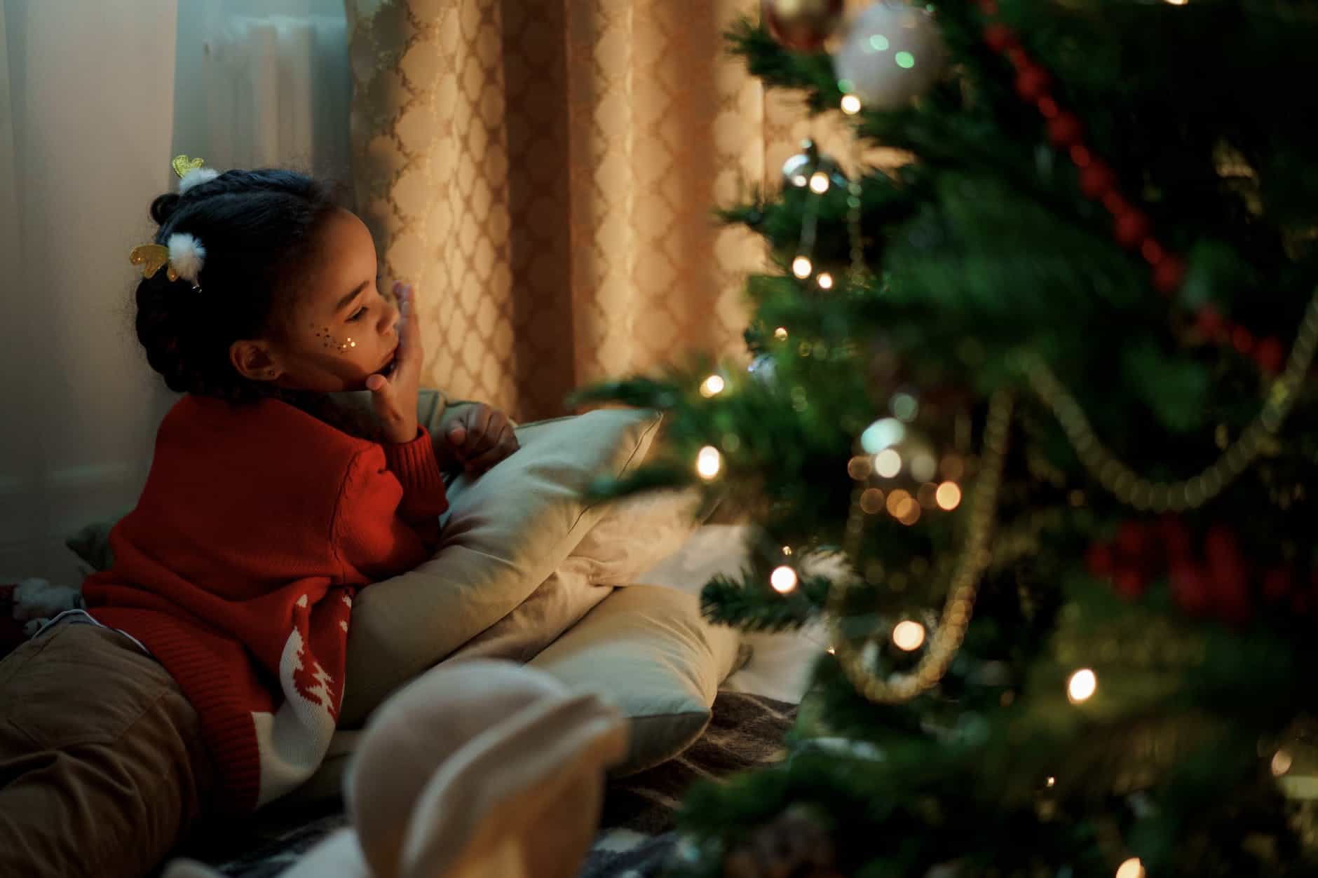 girl in red sweater lying down on pillows