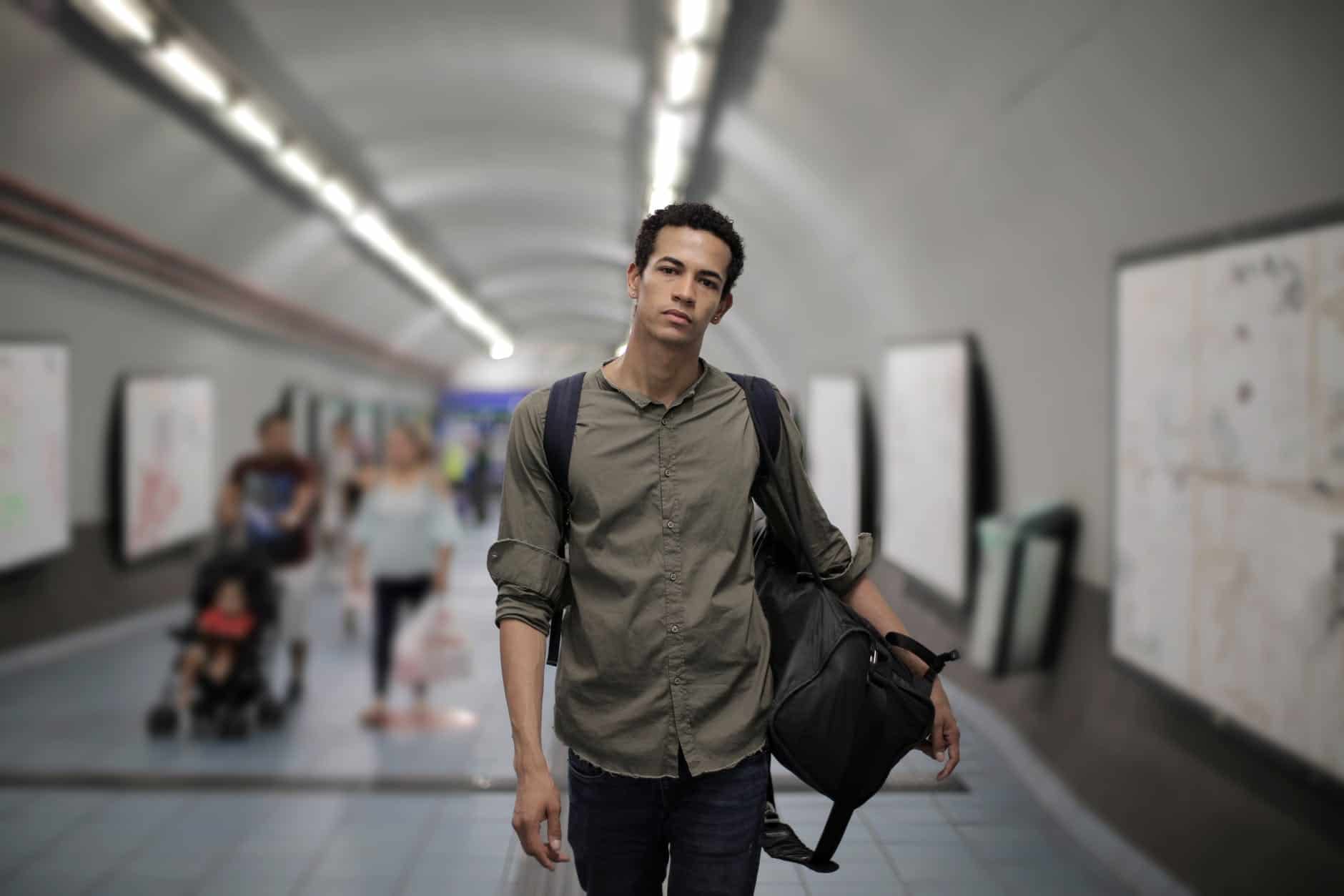 pexels-photo-3799192 serious ethnic man with luggage at subway station in megalopolis