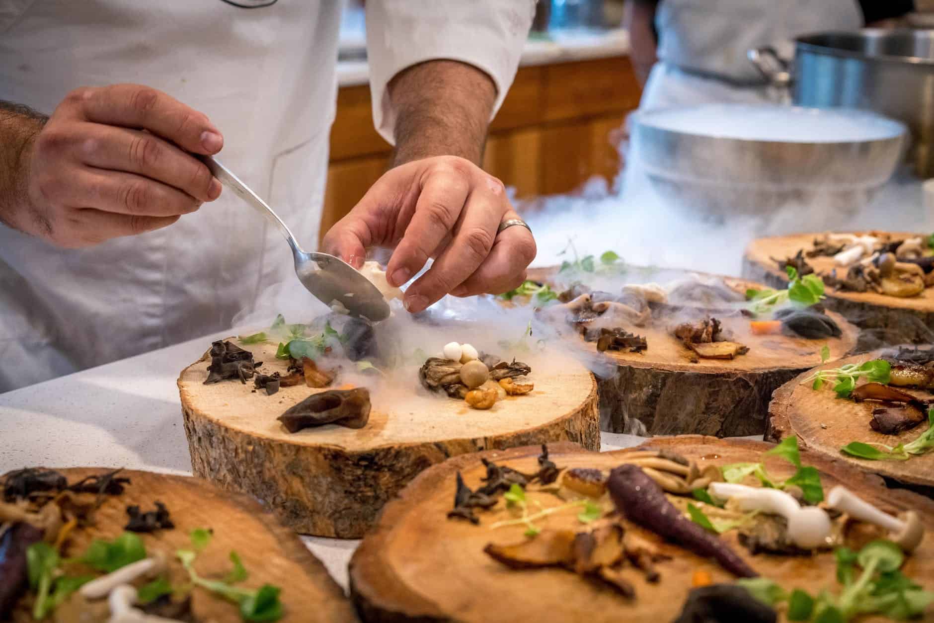 chef preparing vegetable dish on tree slab