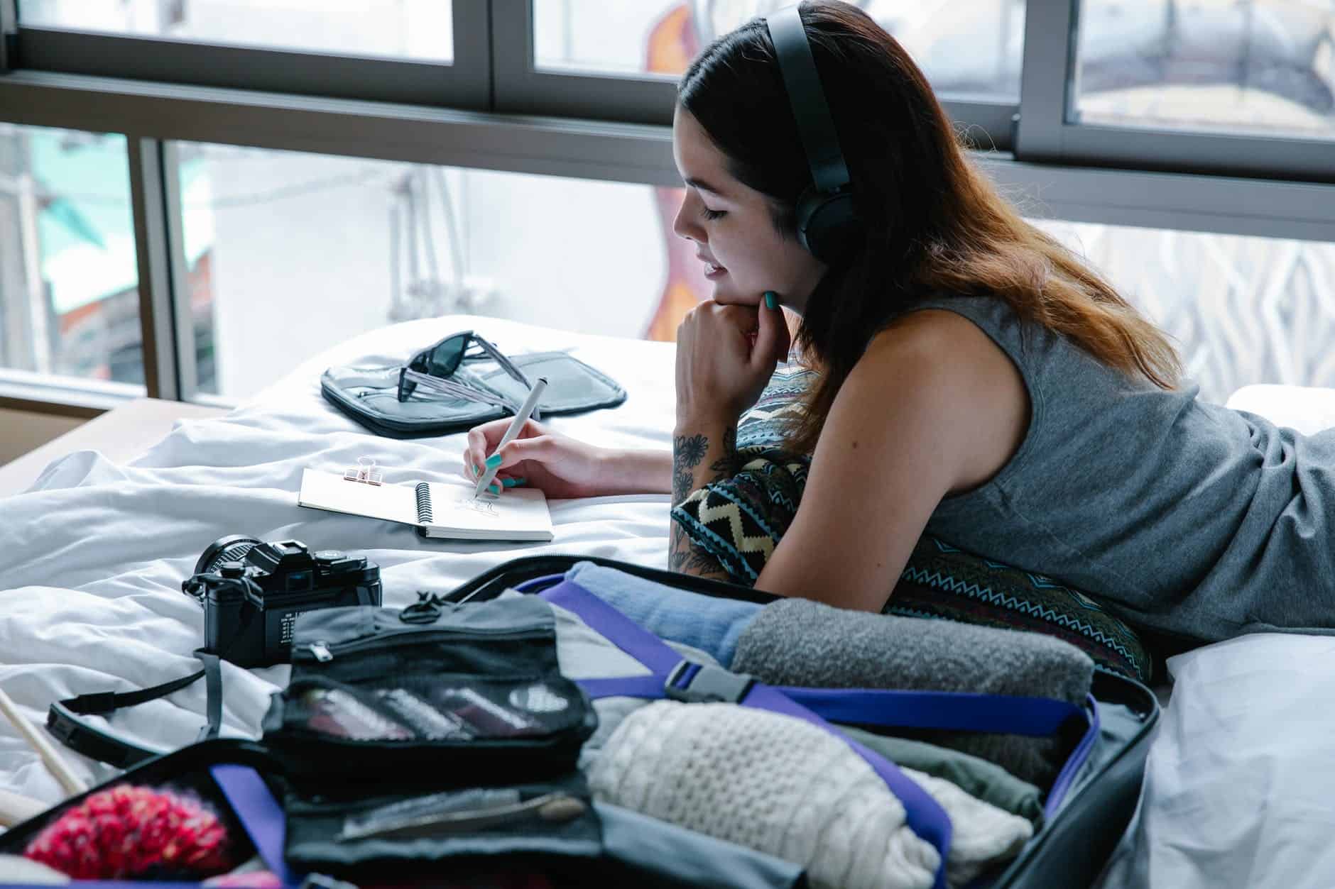 a woman listening to music writing on a notepad