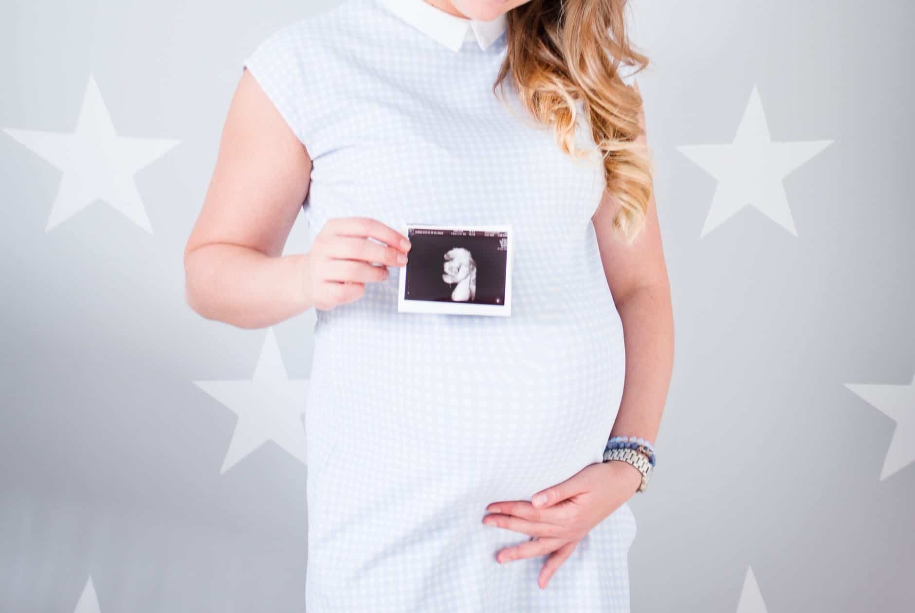 pexels-photo-1145997 woman wearing white cap sleeved dress holding ultrasound result photo