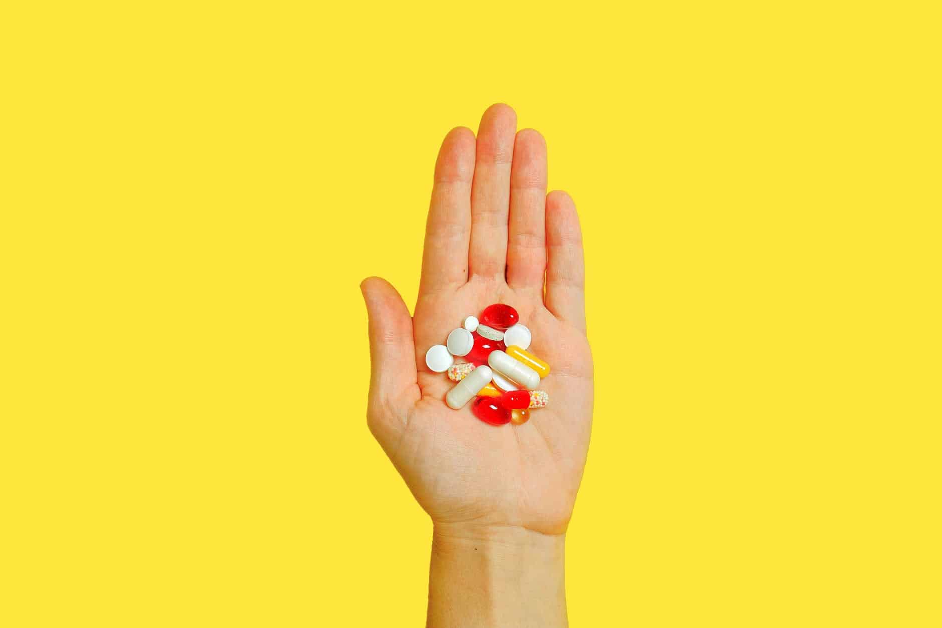 pexels-photo-3683101 person with bunch medication pills on hand
