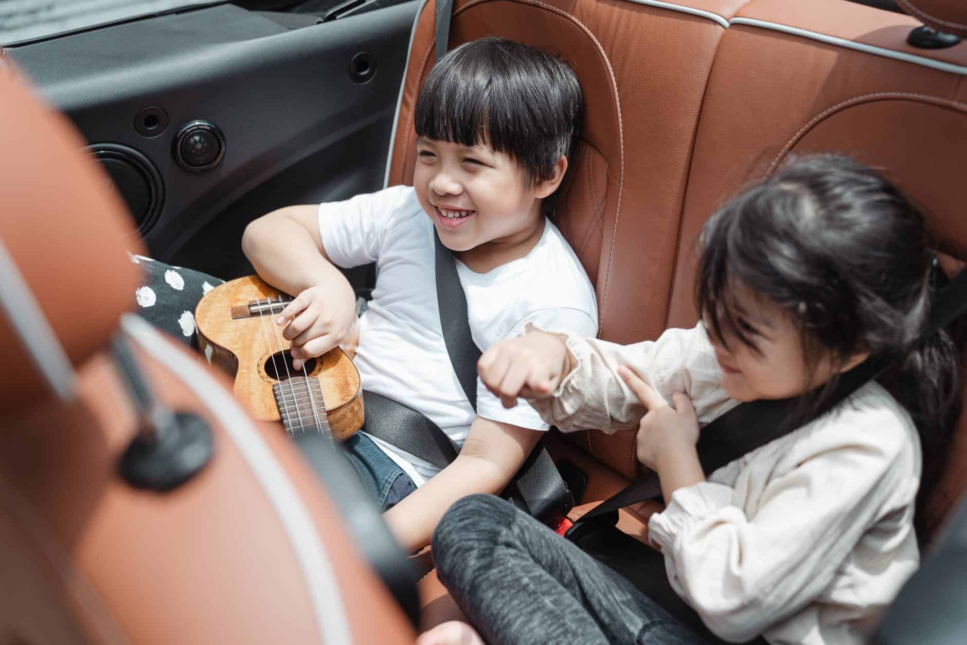 happy asian kids traveling in car