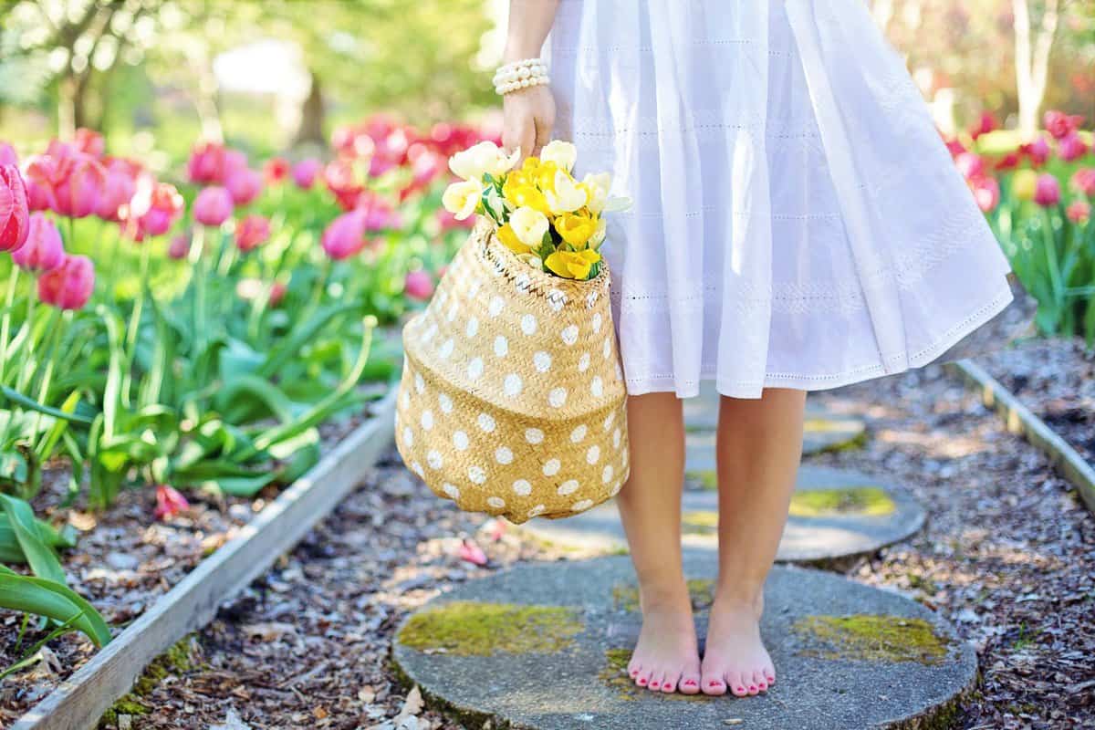 woman holding brown basket with yellow flowers