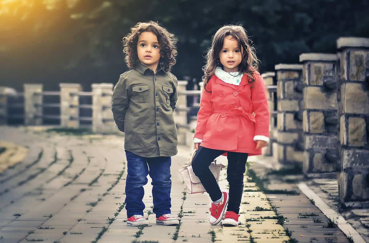 two children standing near concrete fence