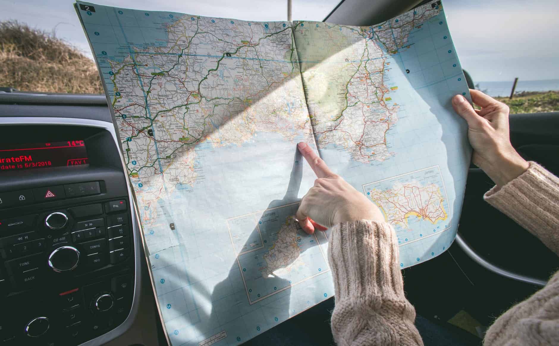 pexels-photo-1252500 person wearing beige sweater holding map inside vehicle