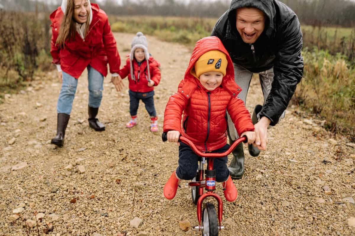 girl in red jacket riding bicycle