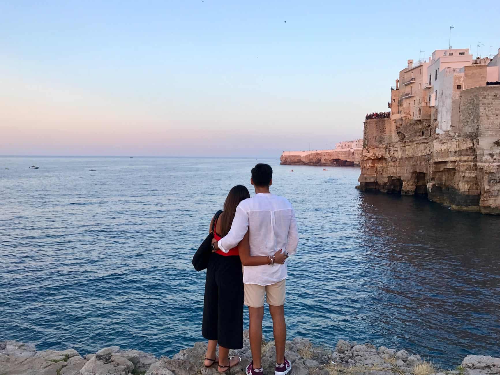 pexels-photo-709478 man in white dress shirt standing beside the woman in black and red dress while watching the blue calm water near brown concrete buildings under white and blue sky at daytime