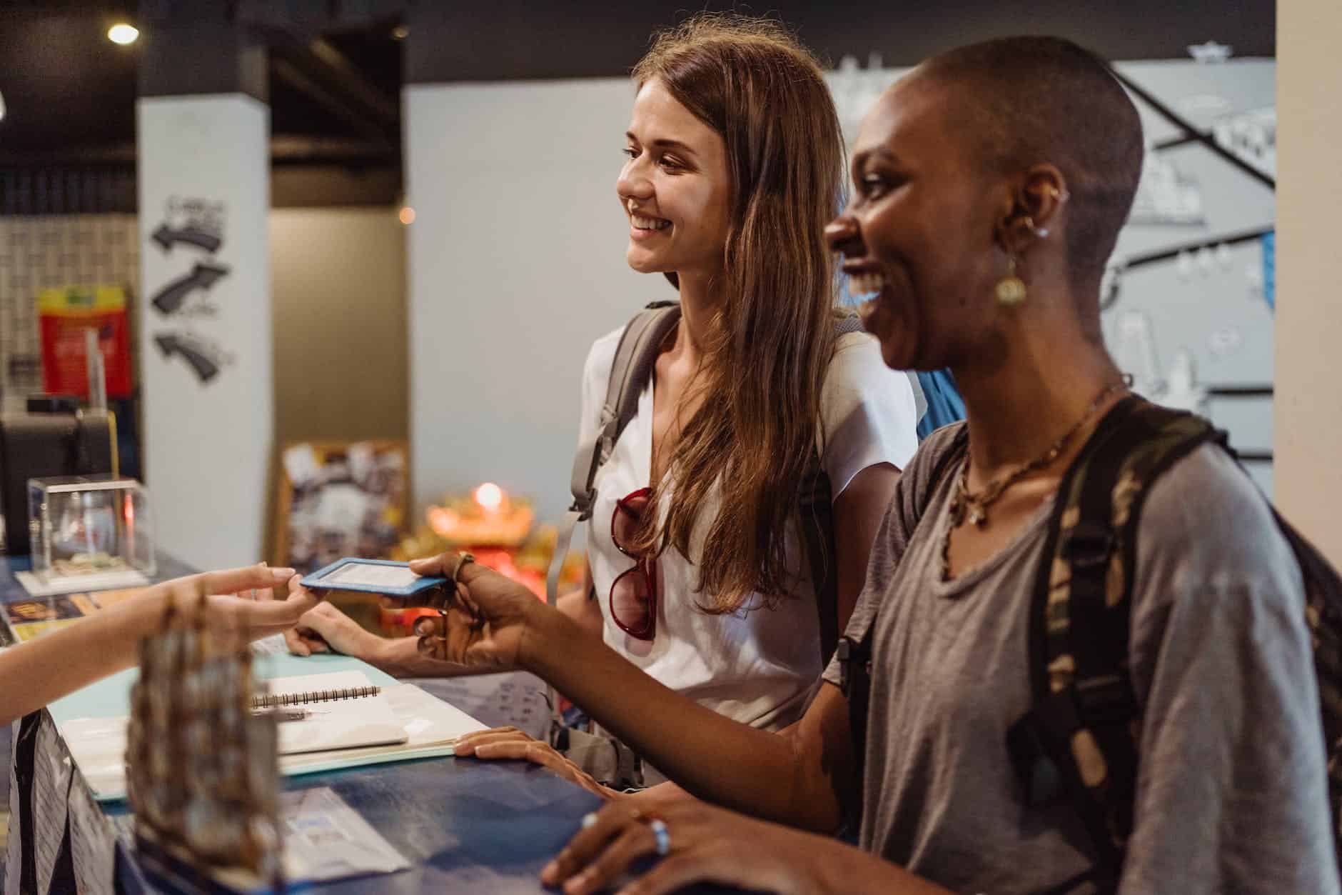 women receiving a hotel room card at the reception desk