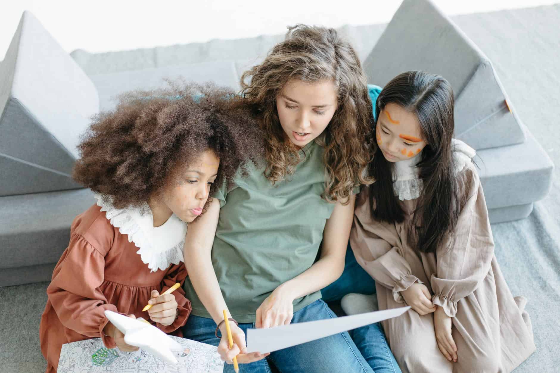 girls sitting beside woman in green shirt