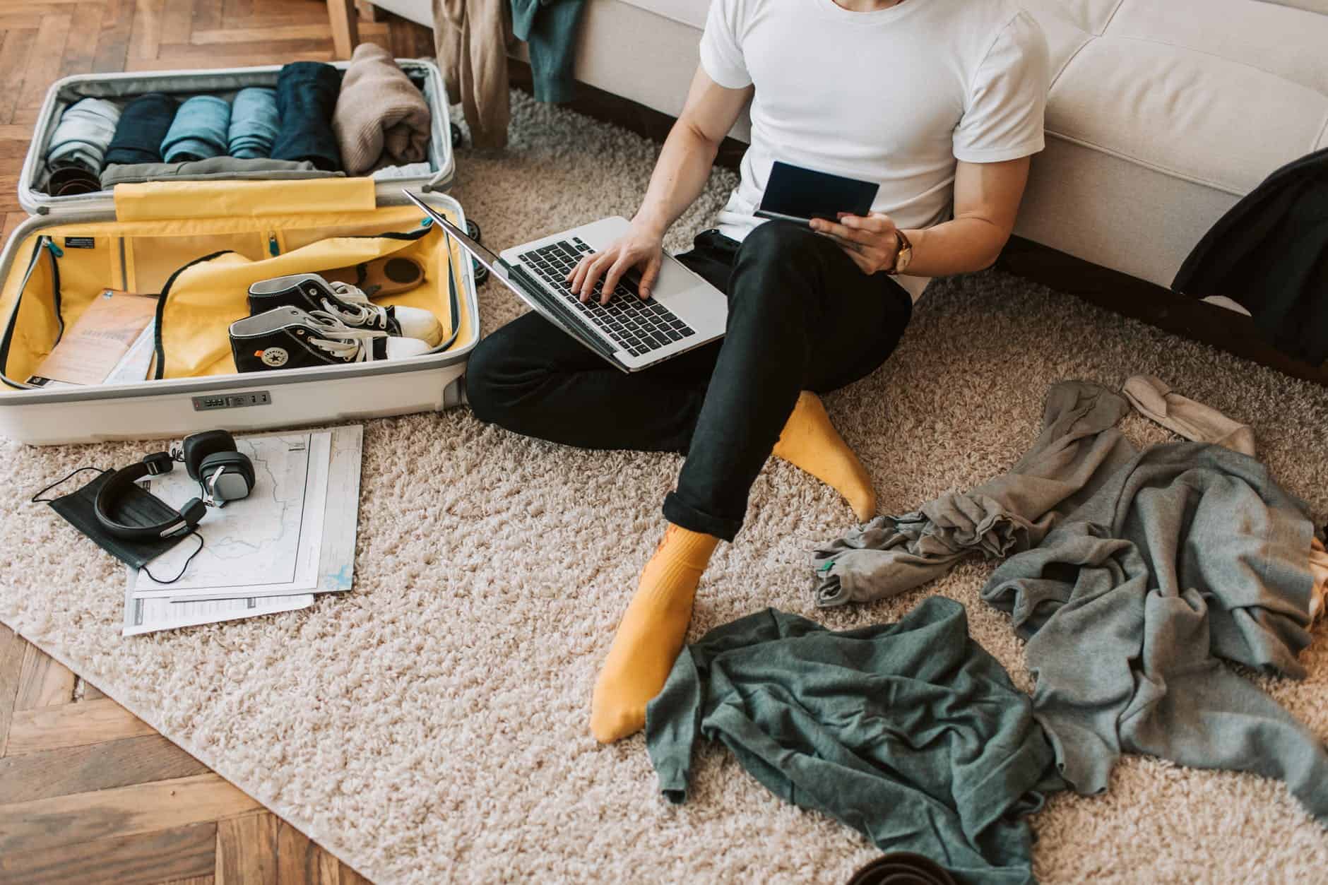 a man using his laptop in a messy living room