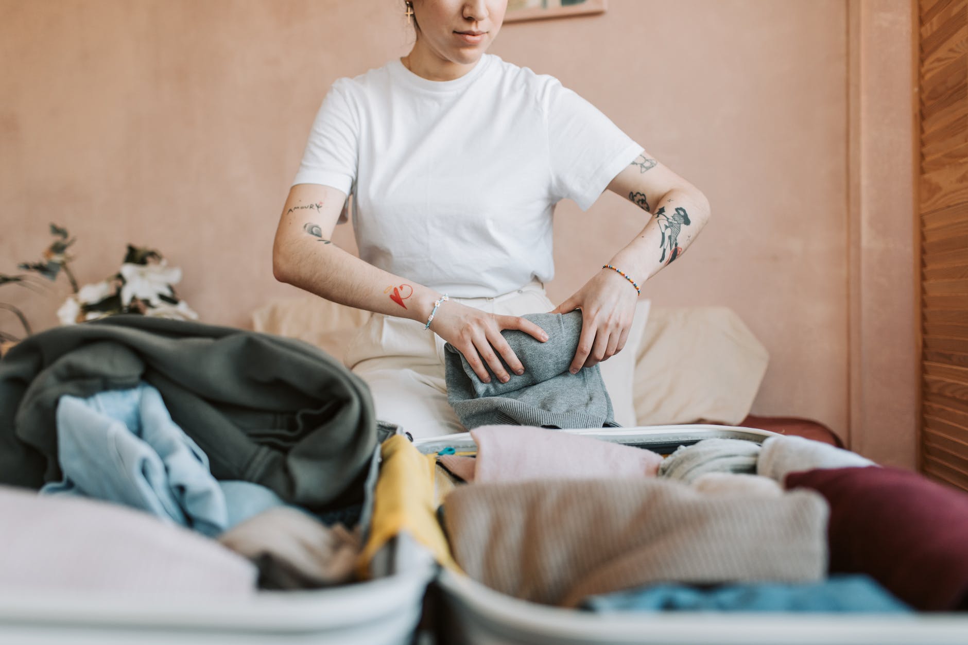 woman in white t shirt folding her clothes