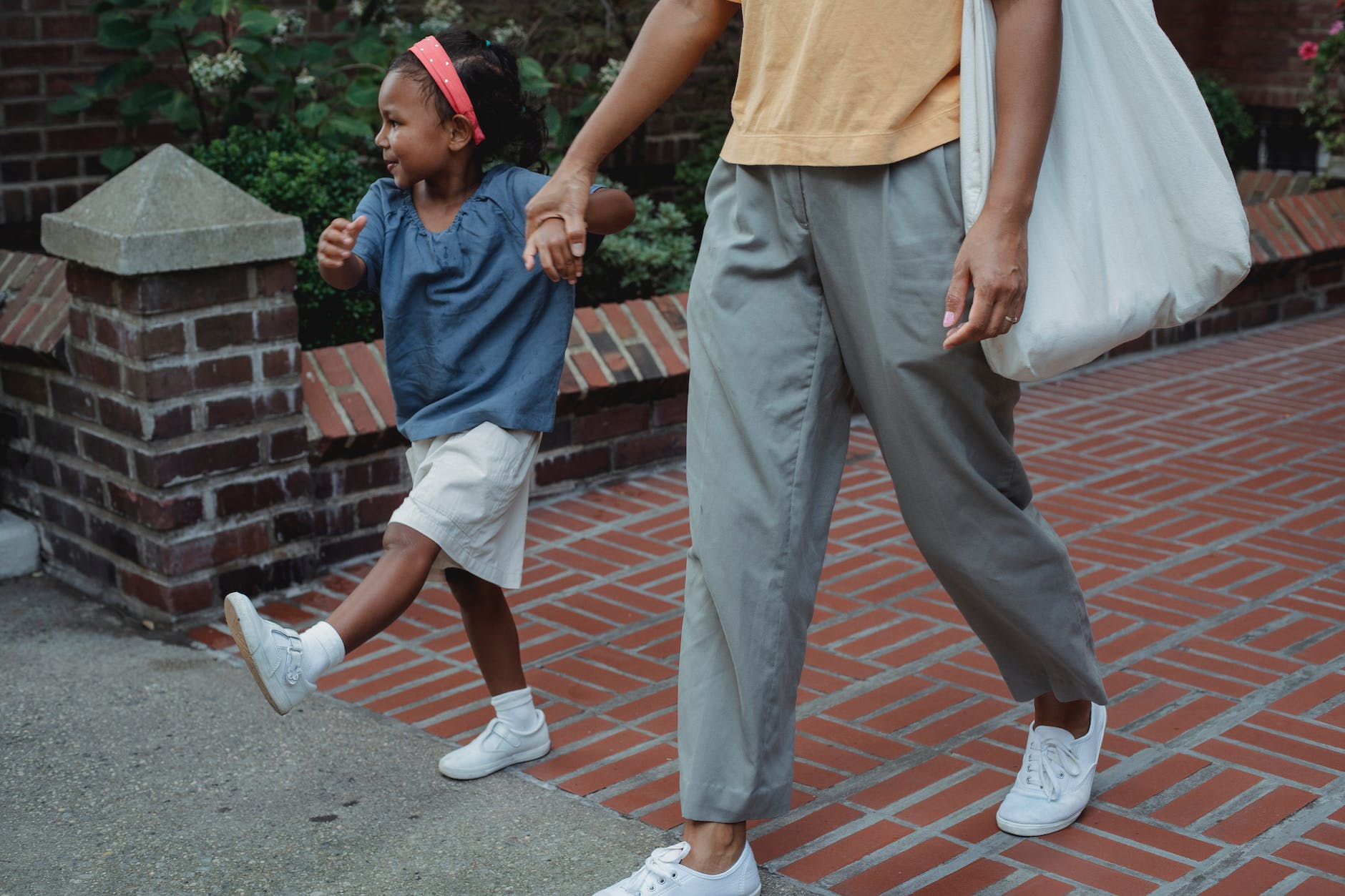 happy asian girl and mother strolling on sidewalk