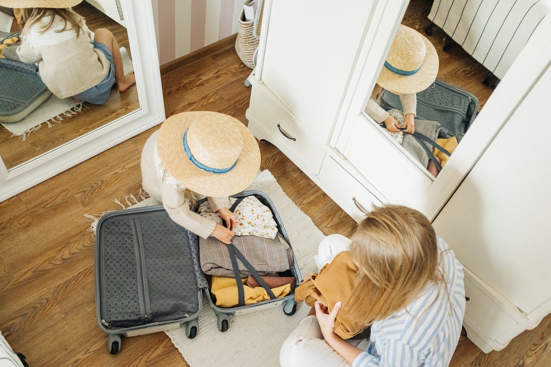 a woman and a child packing a suitcase