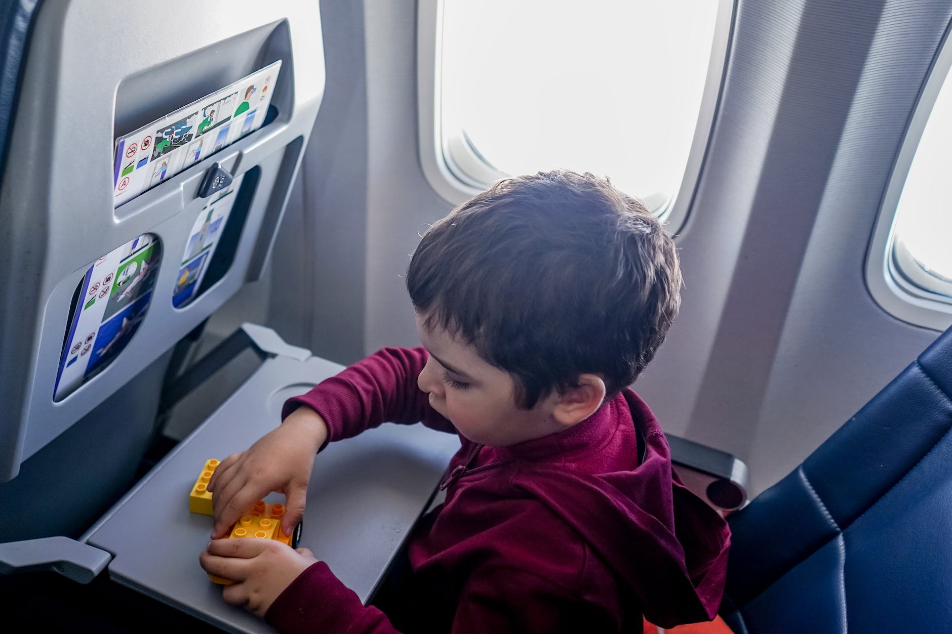 boy playing with toy on plane