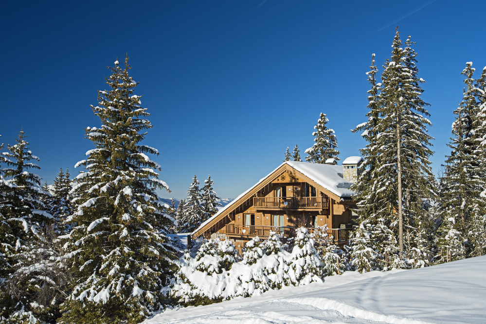 Panoramic view of snow covered trees in an alpine ski resort with apartment buildings on slope