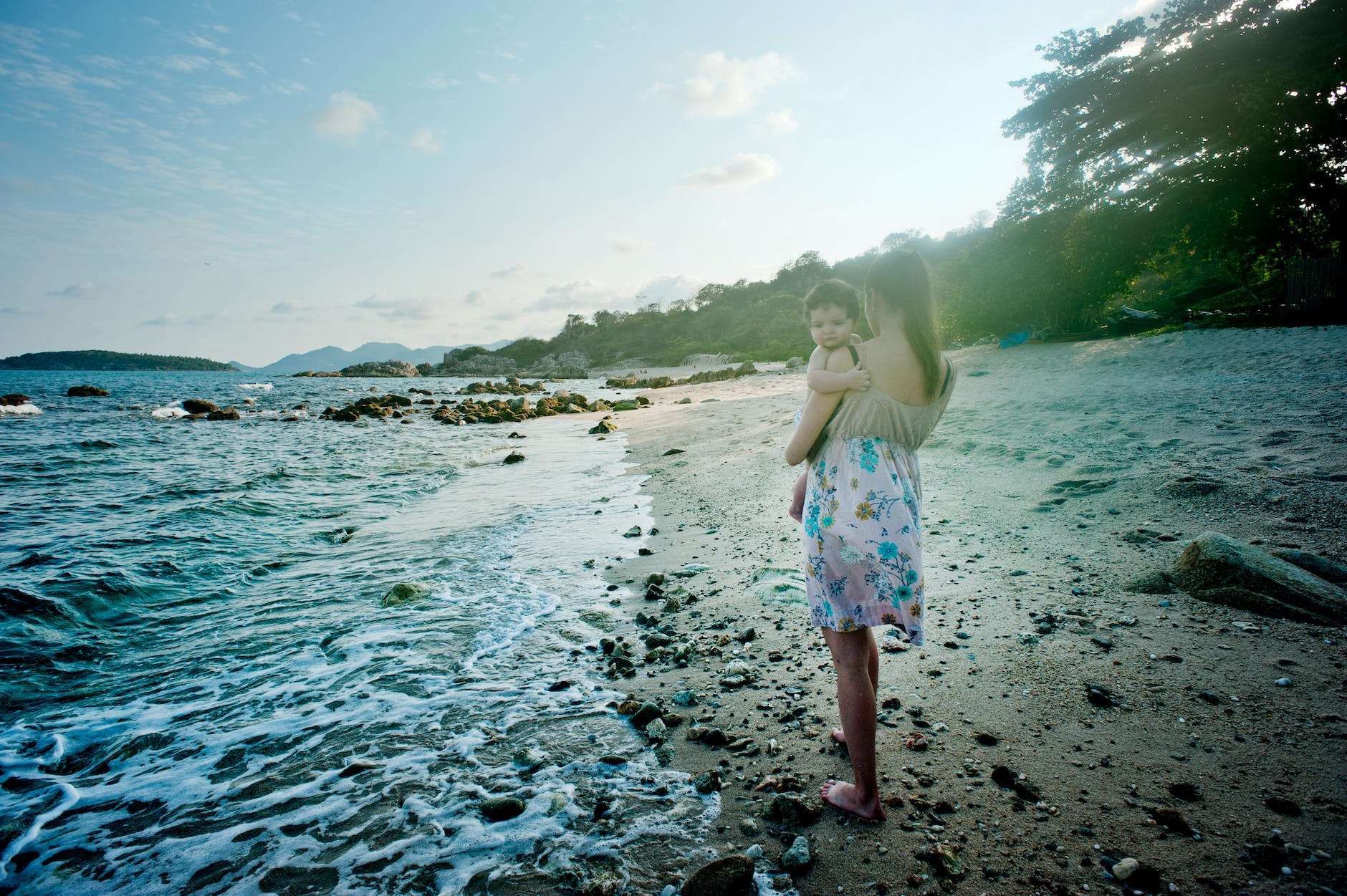 pexels-photo-1002536 woman carrying baby beside the seashore