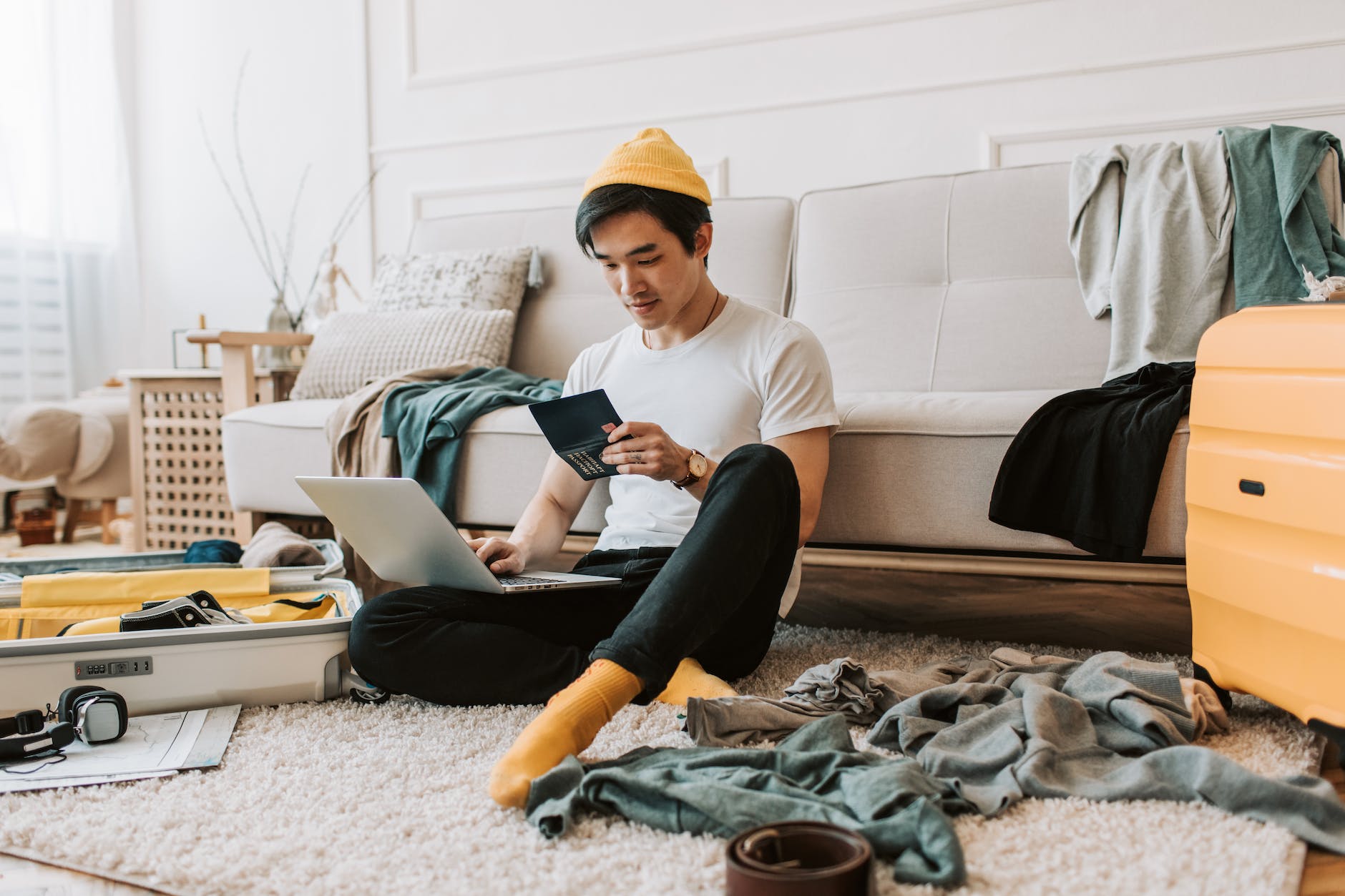 a man using his laptop in a messy living room