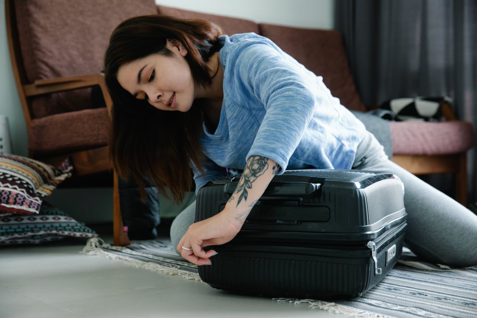 woman zipping a suitcase