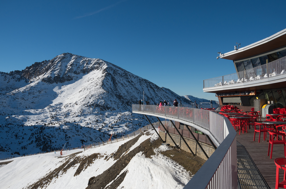 Skiing and snowboarding on the snowy slopes of prepared ski resort in Andorra