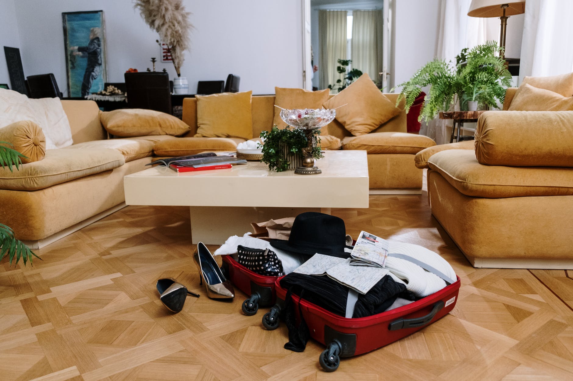 a suitcase with clothes on a wooden floor near the couch