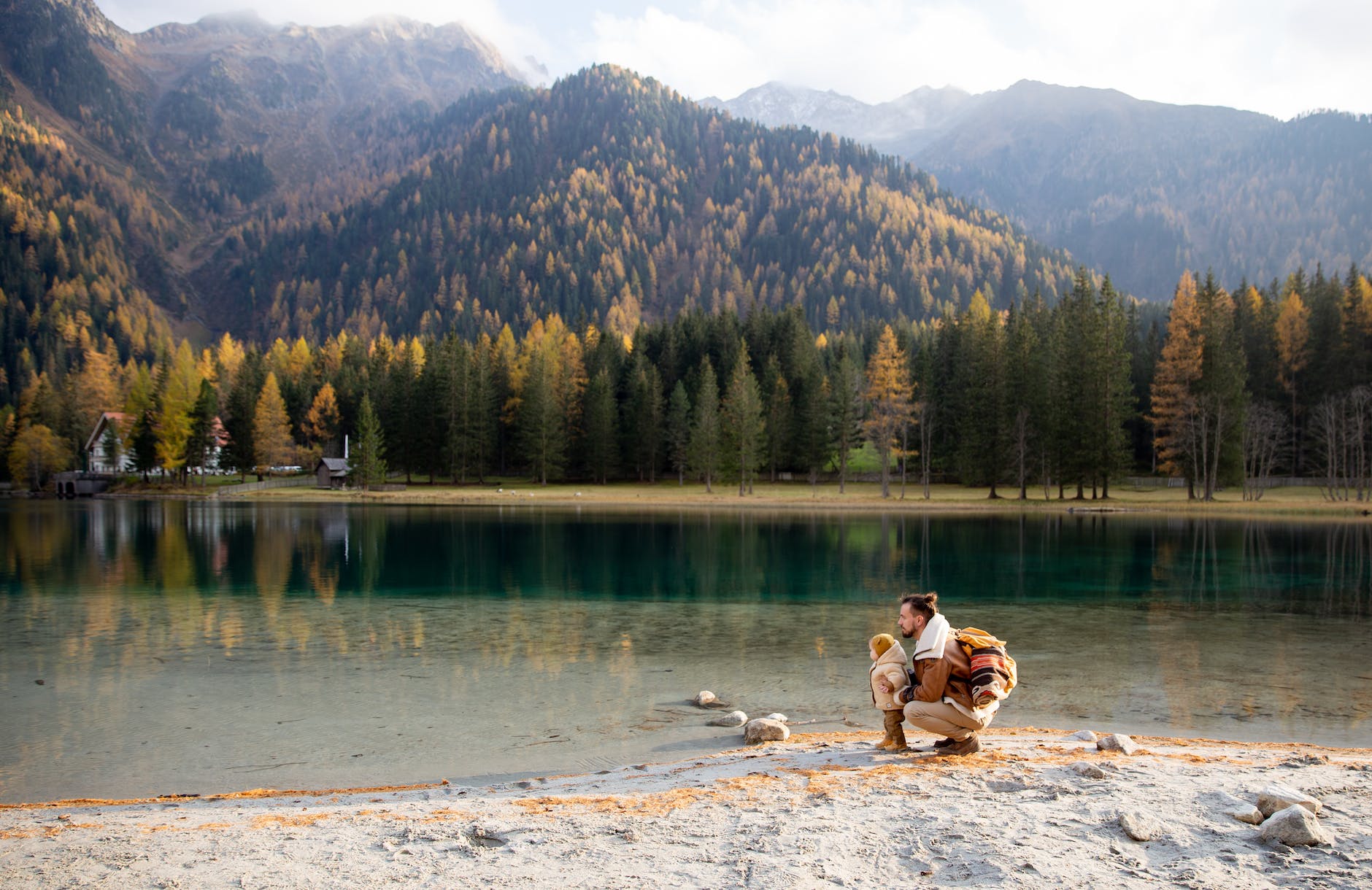 man and child sitting on shore