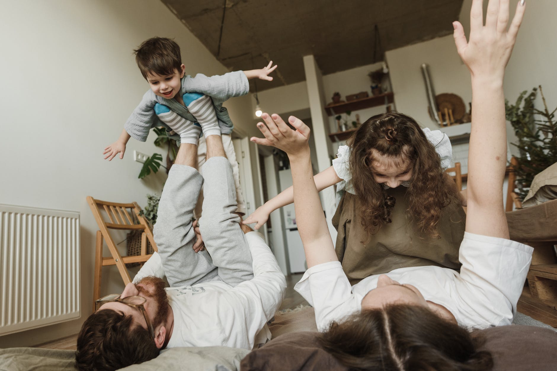 a couple playing airplanes with their children