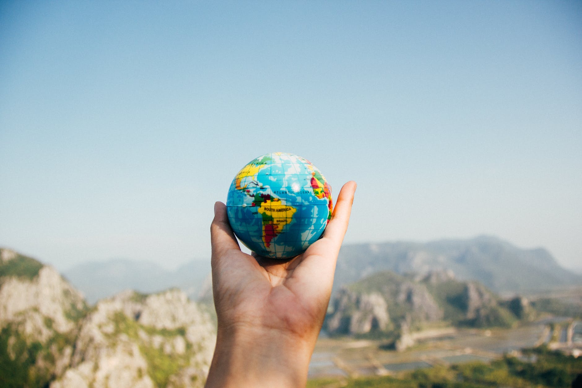 pexels-photo-346885 person holding world globe facing mountain
