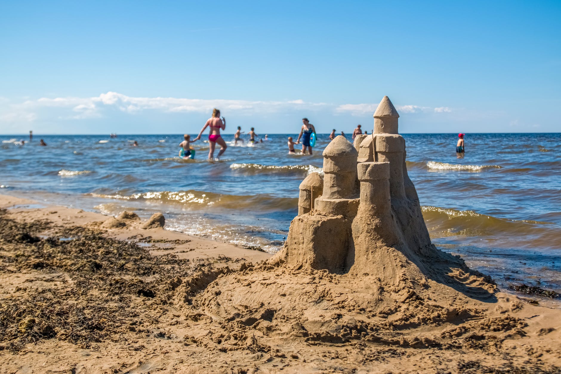 sandcastle built on sunny beach near waving sea
