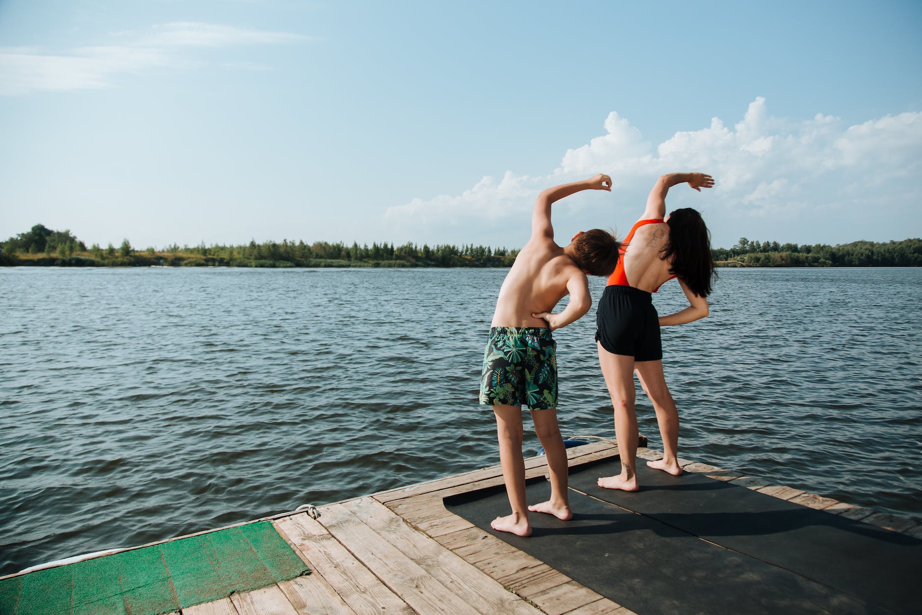 mother and son stretching on jetty