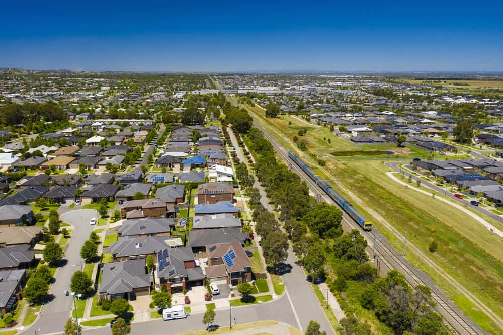 Aerial view of an outer suburb in Melbourne with train passing by