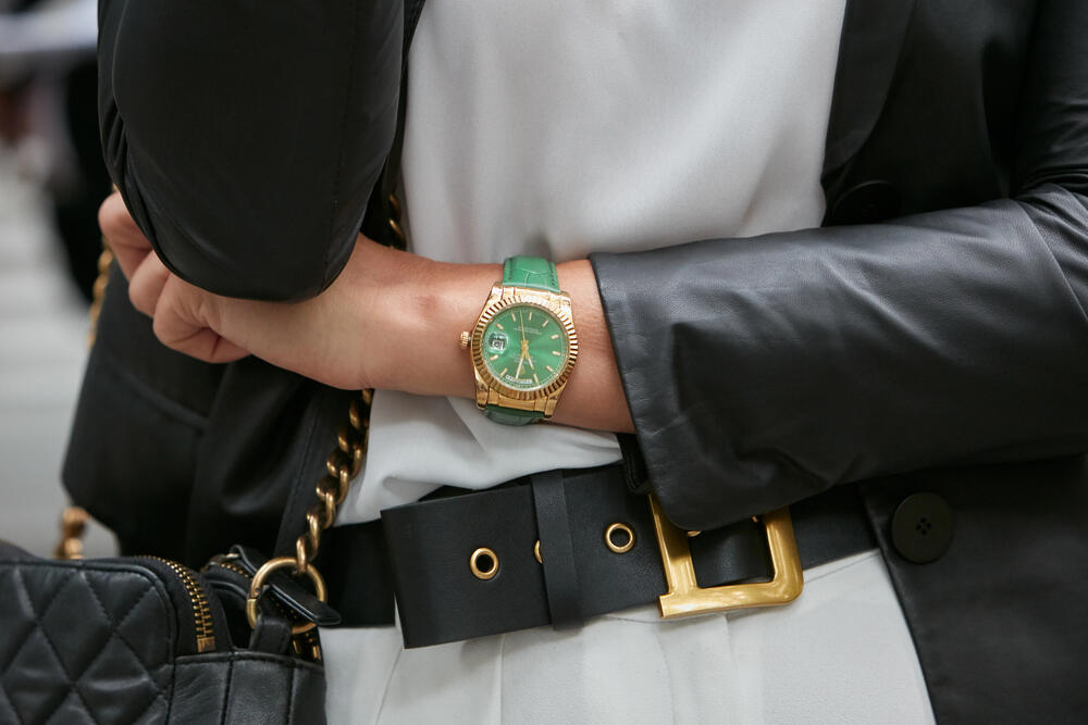 Woman with green and gold Rolex Daydate watch
