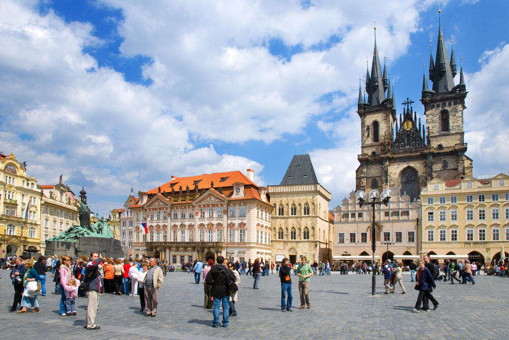 Old Town Square in Prague, Czech Republic, featuring the Church of Our Lady before Týn, historic buildings, and tourists enjoying the UNESCO World Heritage site.