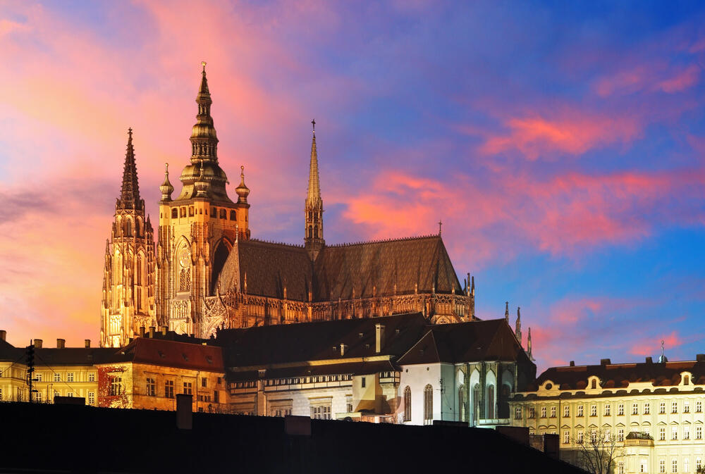 St. Vitus Cathedral at Prague Castle illuminated at sunset with a vibrant pink and blue sky, a must-see landmark in the Czech Republic's capital.