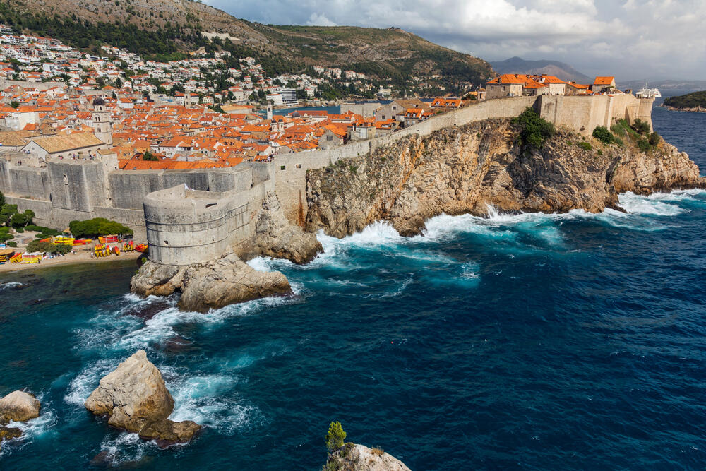 Aerial view of Dubrovnik’s ancient city walls perched above the Adriatic Sea—perfect for family holidays with historic walks, panoramic views, and coastal charm